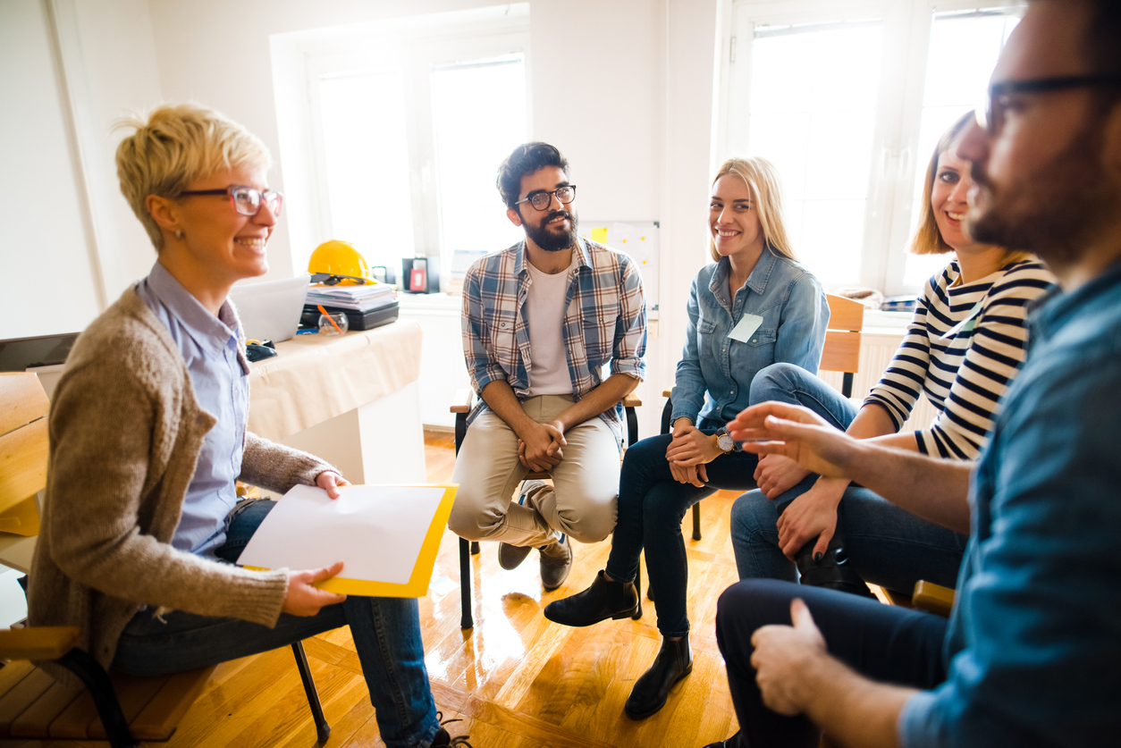 A group of smiling people sit in a circle.