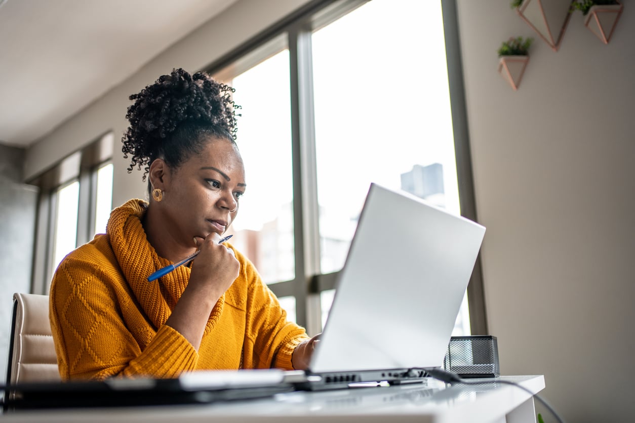 A woman working on a laptop in an office.