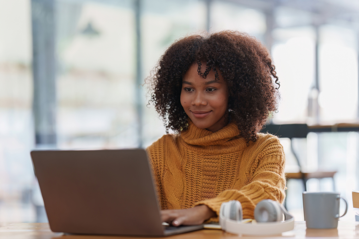 A smiling woman working on laptop.
