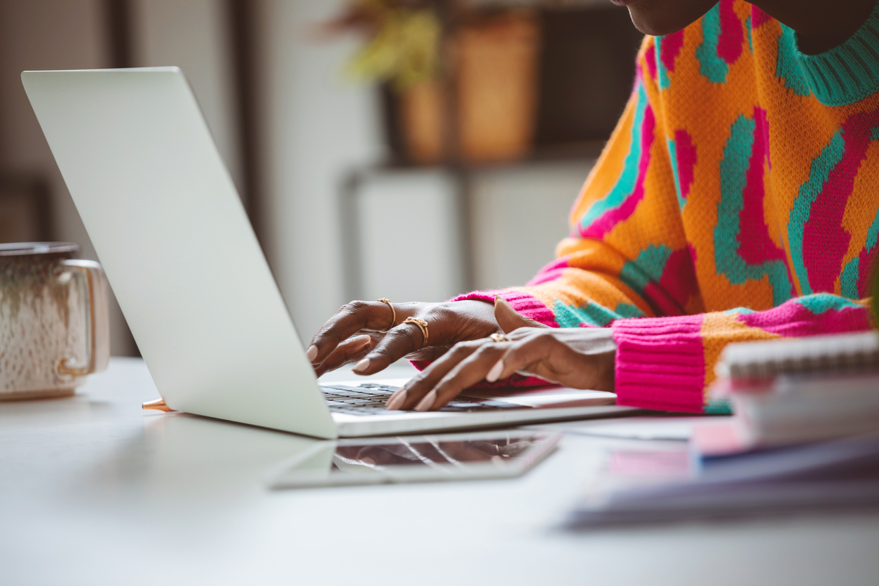 A woman typing on a computer at a desk.