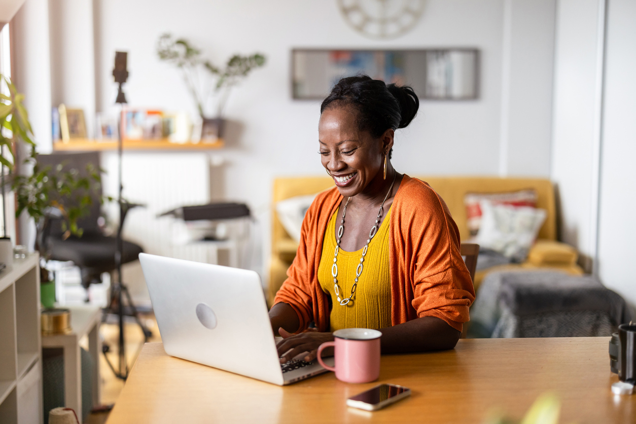 A woman working on a laptop in a living room.