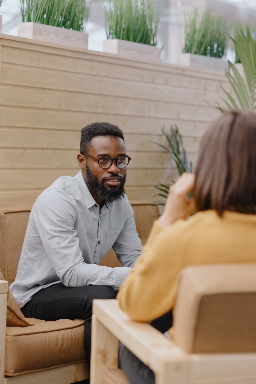 A man sits talking to a therapist.